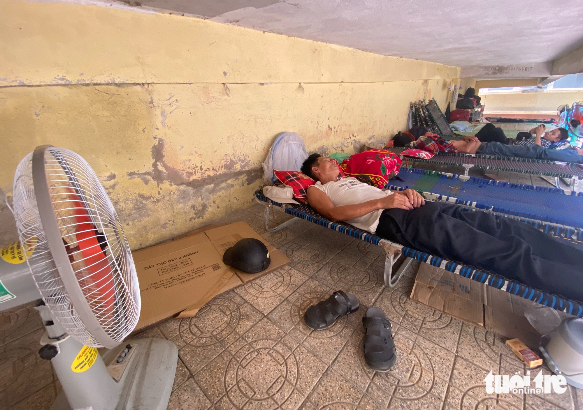 Người nhà bệnh nhân nằm gầm cầu thang tránh nắng nóng 40 độ C 1 nắng nóng - Ảnh 1.