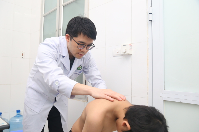 Bác sĩ kiểm tra tình trạng vẹo cột sống cho trẻ. Ảnh: Lê Nga