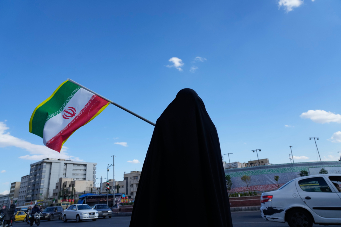 Người phụ nữ cầm cờ Iran trên đường phố ở Tehran hôm 30/3. Ảnh: AP