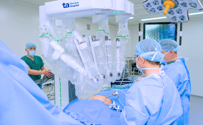 Bác sĩ mở lỗ nhỏ đưa 4 cánh tay robot vào lồng ngực trước khi điều khiển robot cắt khối u cho bệnh nhân. Ảnh: Bệnh viện Đa khoa Tâm Anh