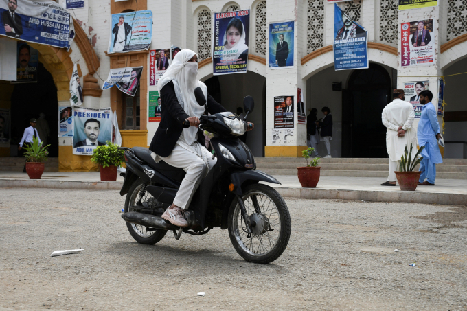 Cô Mehwish Qureshi, 33 tuổi, lái xe máy điện ở Hyderabad, Pakistan ngày 2/4. Ảnh: Reuters