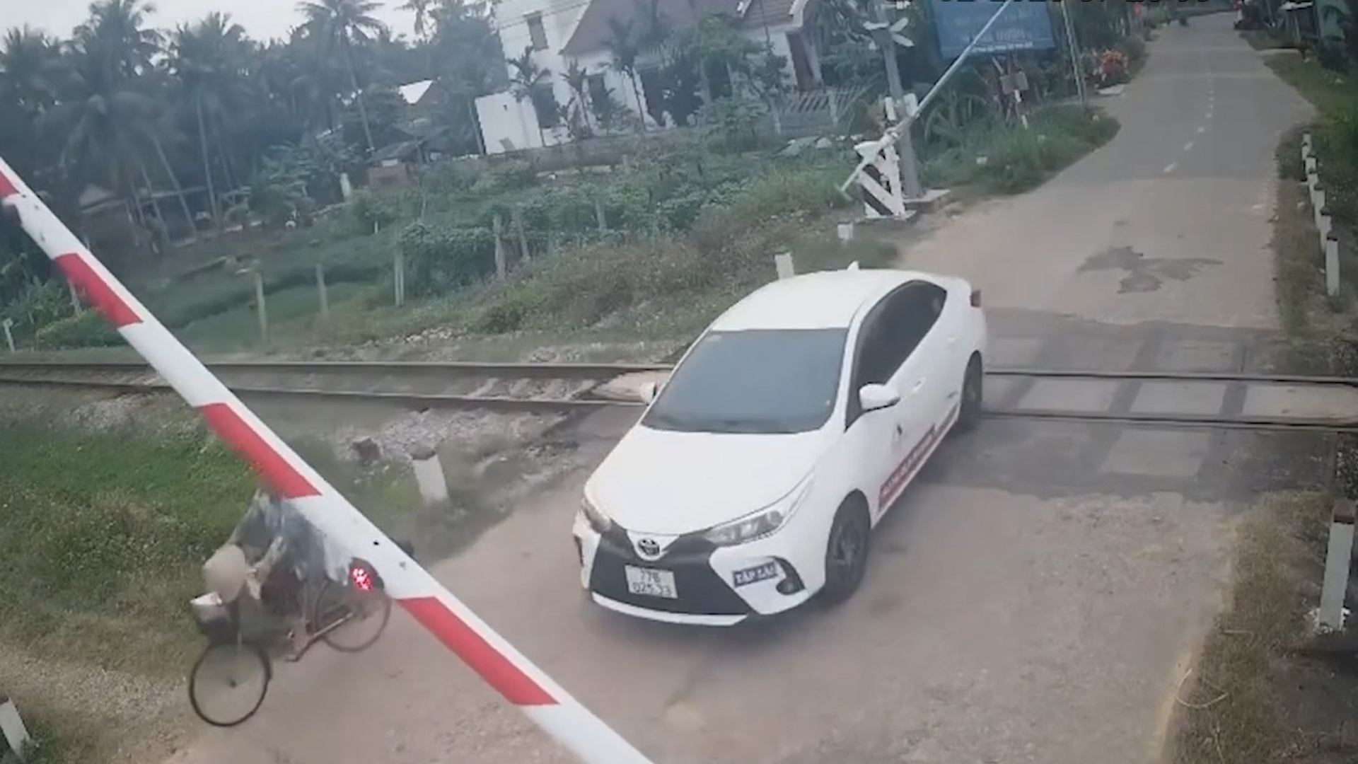 Xe tập lái bất chấp đèn đỏ và rào chắn, cố tình băng qua đường ray - Ảnh 1.